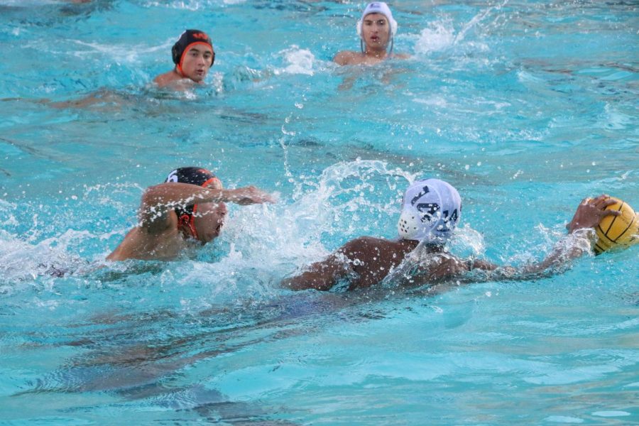 Sophomore+Kian+Bhatt+escapes+a+defender+as+he+swims+away+with+the+ball.