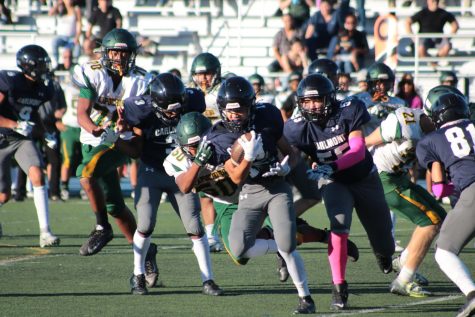 Wide receiver Ryan Kwan runs the ball as others try to tackle him down. 