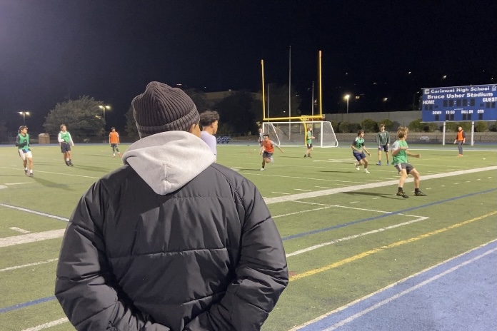 Jose+Caballero+stands+on+the+sideline+as+he+watches+the+varsity+boys+soccer+practice.