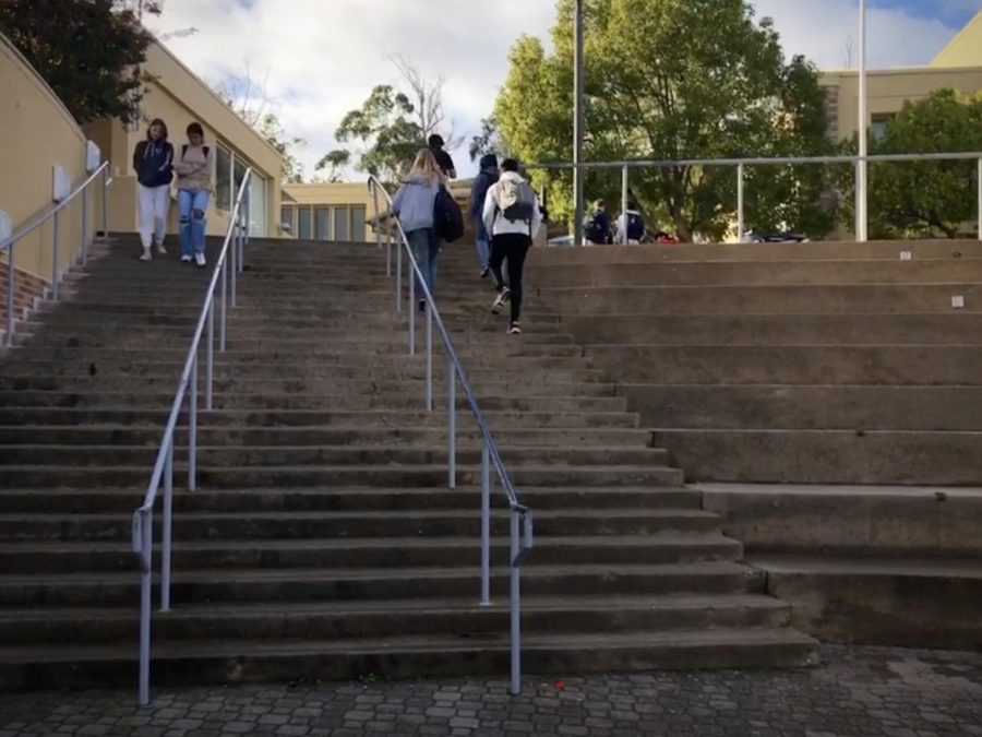 Students walk the quad steps that lead toward the football field. This is just one of the many staircases all across Carlmonts hilly campus.