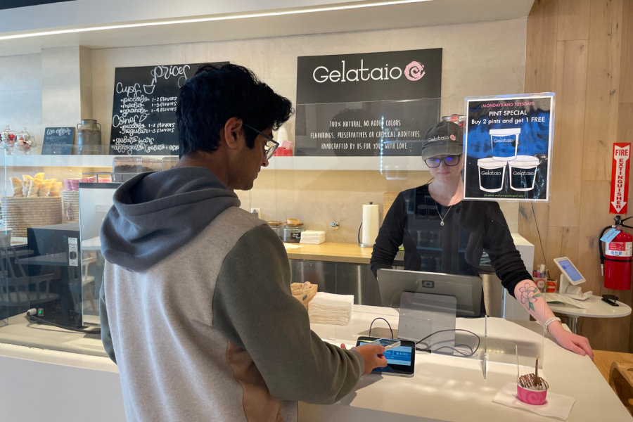 A teenage customer uses  Apple Pay to buy gelato
