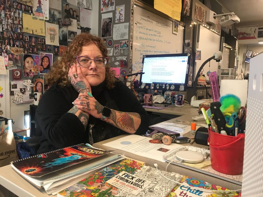 Julia+Schulman+sits+at+her+colorful+desk+in+her+classroom.
