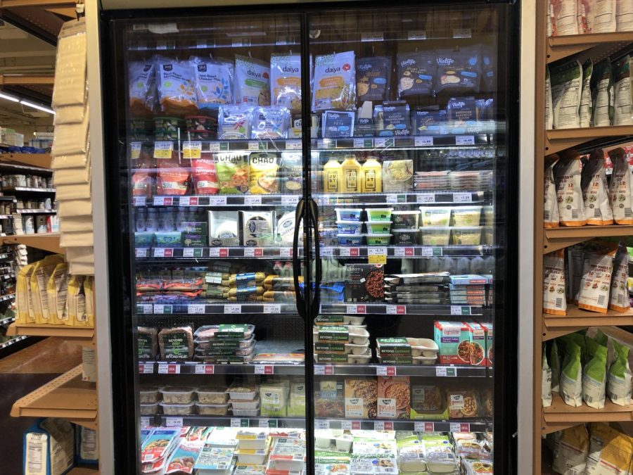 Rows and rows of vegan options for a holiday feast sit in a fridge at Whole Foods. The options range from tofu to non-dairy cheese.