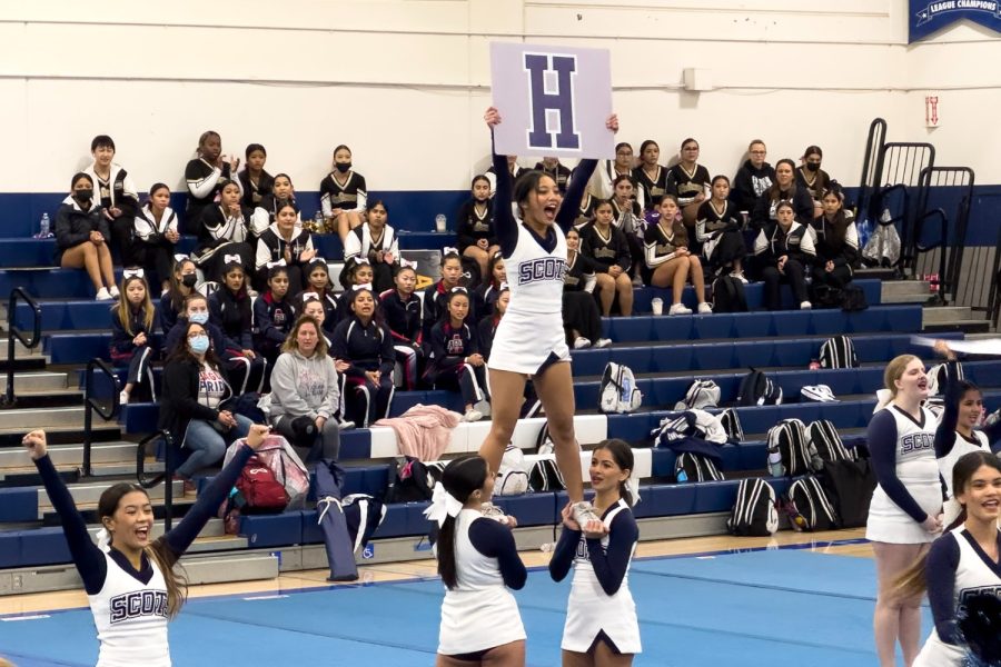 Sophomore Makayla Miller holds up a sign with an H for a cheer during the JV competition teams routine at the Branham Invitational. The cheerleaders held up the letters C, H, and S during the cheer.