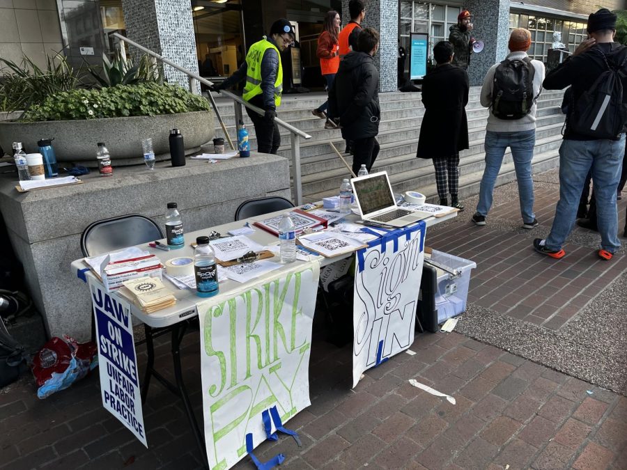 As people listen to motivated speakers, the sign-in table at the UCSF protest proudly displays signs advertising their protest. 