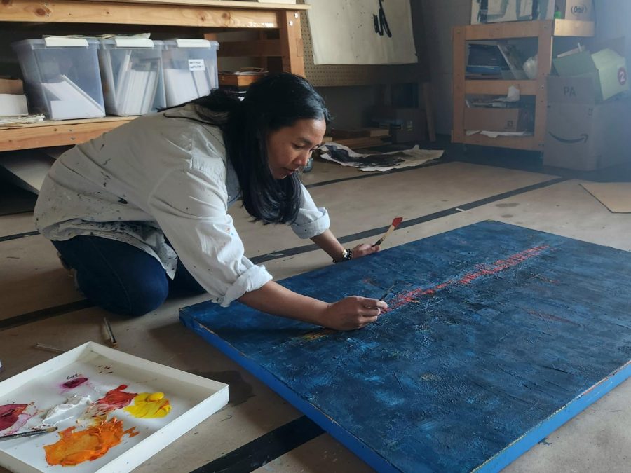 Maricris Hansen works on a painting in her studio.