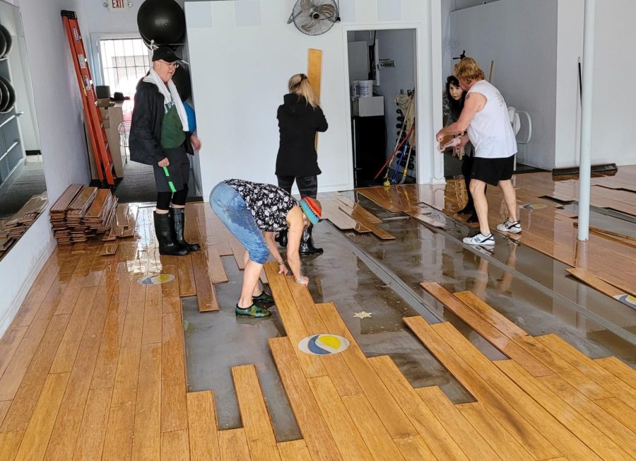 Volunteers+and+workers+help+to+replace+the+waterlogged+flooring+inside+the+Jazzercise+building.