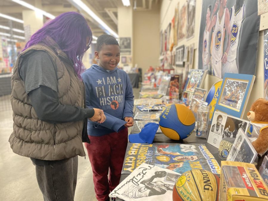 Carolyn Hoskins shares the modern day basketball exhibit with an interested youth exploring the pop up museum. 