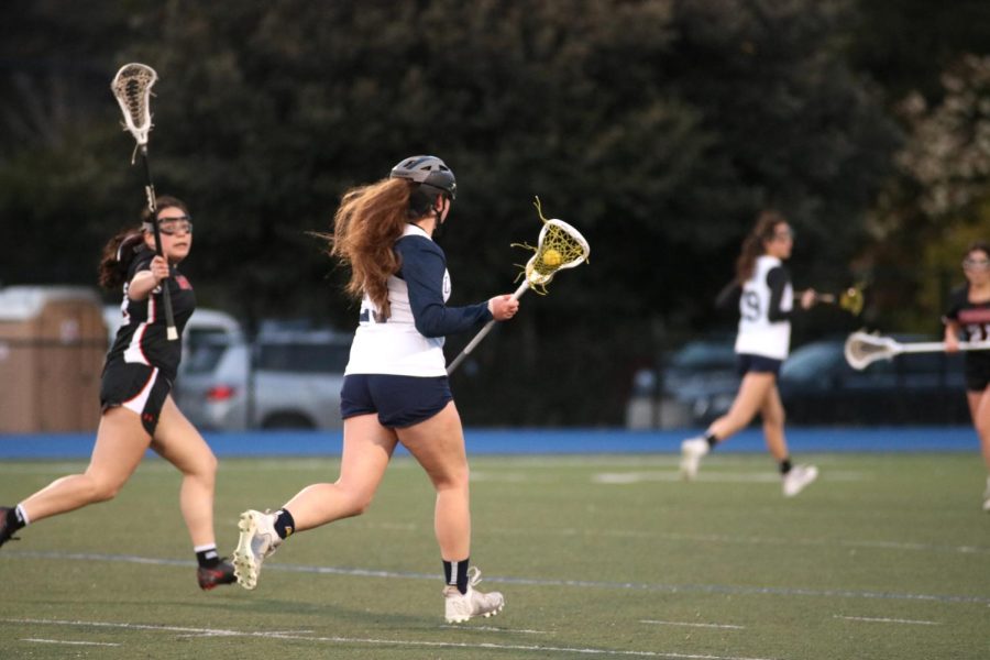 Sophomore Samantha Levitt possesses the ball up the field as she looks for an open pass.