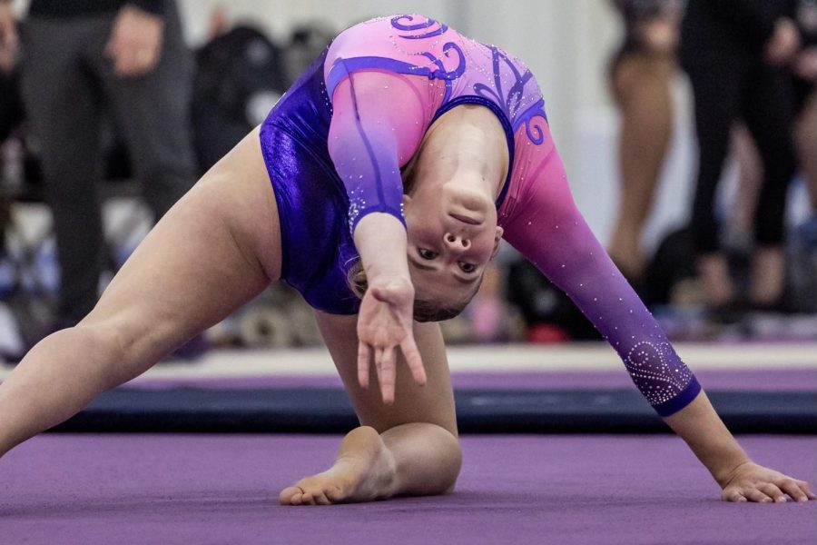 Bryce Kupbens stretchs into her next pose during a floor routine.