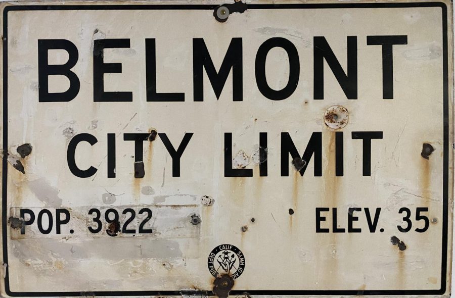 Belmont city limit sign hanging on the wall of the History Room. The bullet holes peppering the sign indicate the rural, Wild West, origins of Belmont.