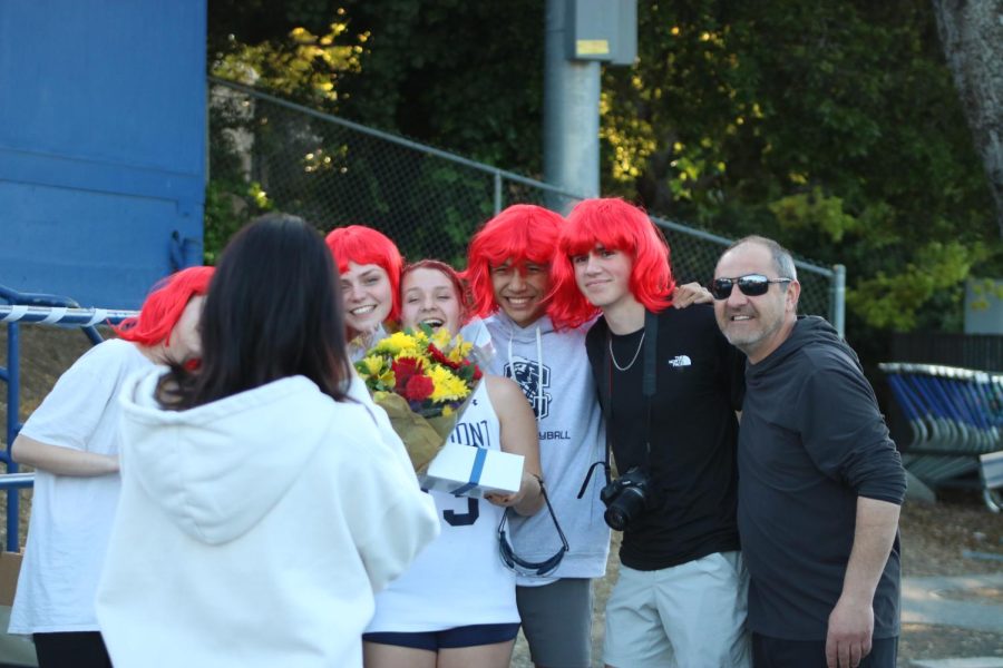 Senior Natalie Dronskiy surrounded by her red wig-wearing supporters.