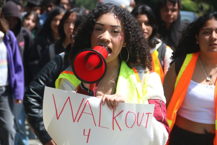 Nora Acosta, one of the leaders of the walkout and a Black Student Union (BSU) officer, leads a chant as the students exit the campus, her voice amplified through a megaphone. Guiding the students as they pour out of the campus, her chant ignites a collective spirit, empowering each protester to lend their voice and complete the chorus.