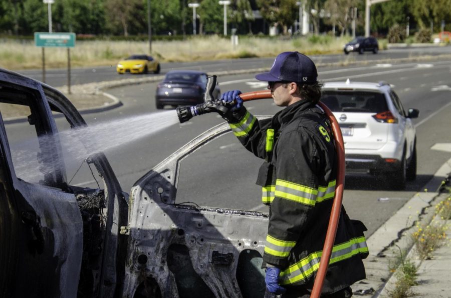 A firefigheter extinguishes what remains of the Silverado that caught fire this afternoon.