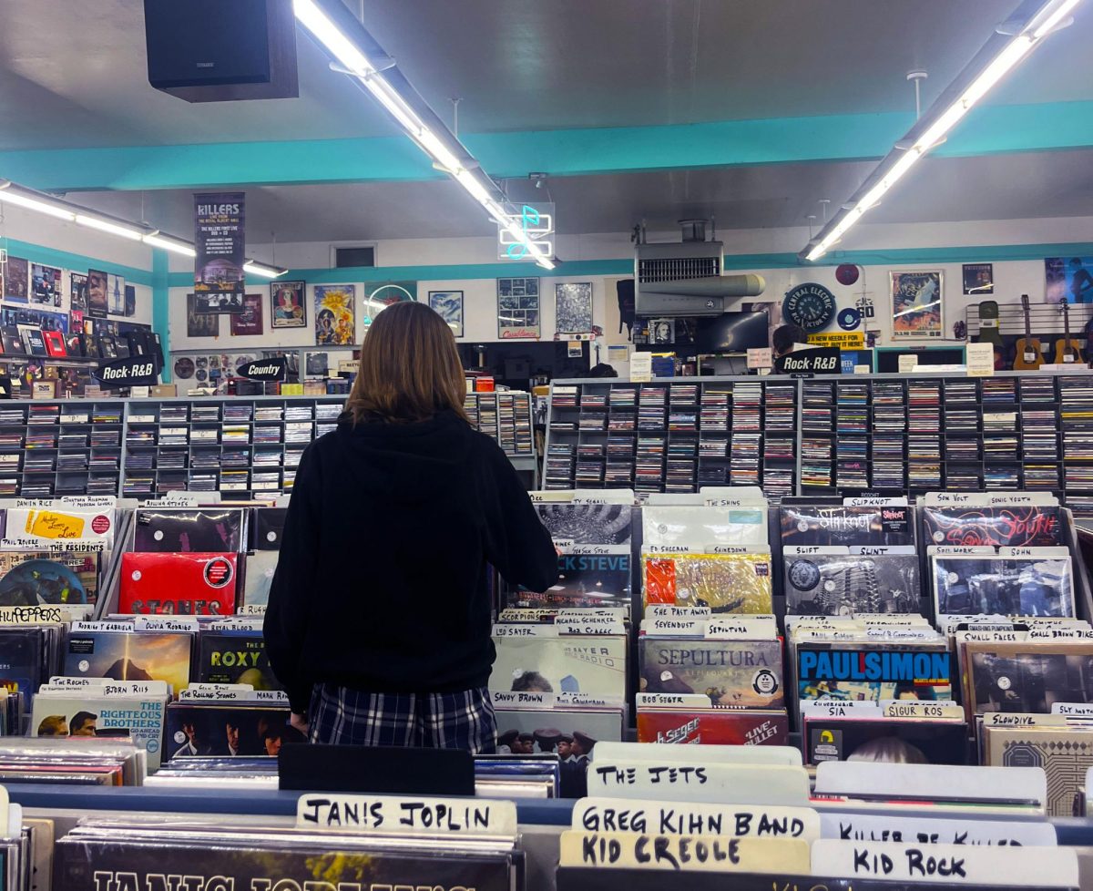 Student looking through the wide variety of vinyls and music memorabilia sold at Vinyl Solution Records in San Mateo.