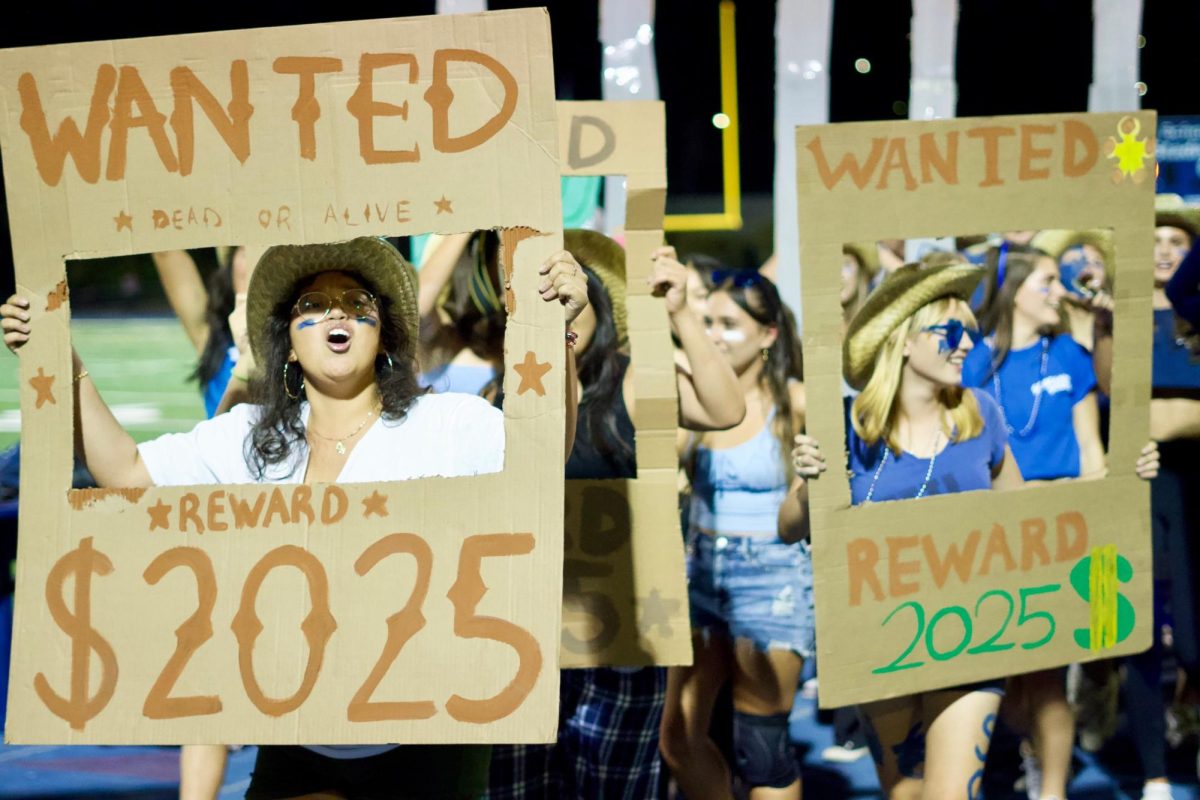 Junior Kimberly Garcia Cancio holds up a handmade sign during the homecoming float parade. The junior class theme was “Junior Jail,” following the western theme of the Homecoming dance. The signs were creatively decorated with their year of graduation, 2025. 
