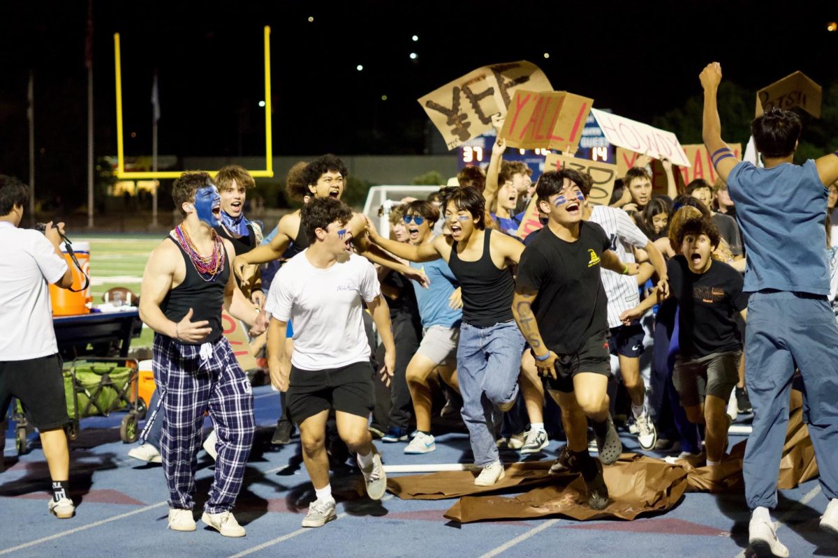 Seniors joyously scream and cheer at the top of their lungs, celebrating the senior class homecoming float. They ran along the track after breaking out of the float. Their theme was “Senior’s Last Rodeo,” which was a creative title to commemorate their last homecoming game.