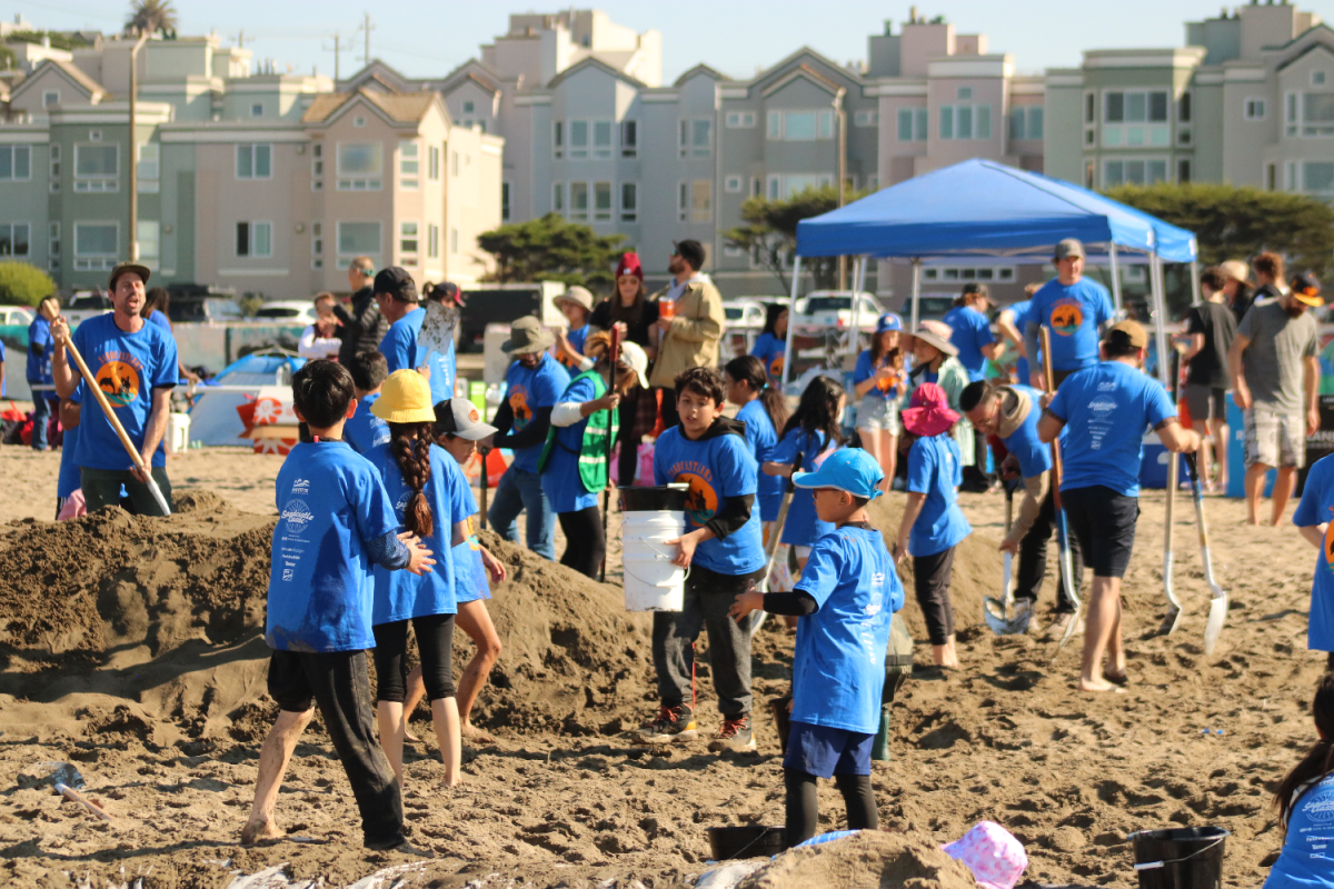 Members of Team Sandcastlers begin working on their sandcastle, using shovels and buckets to move the sand. The teams were forbidden from using any machinery to help with the building; only manual tools, like shovels, were allowed.