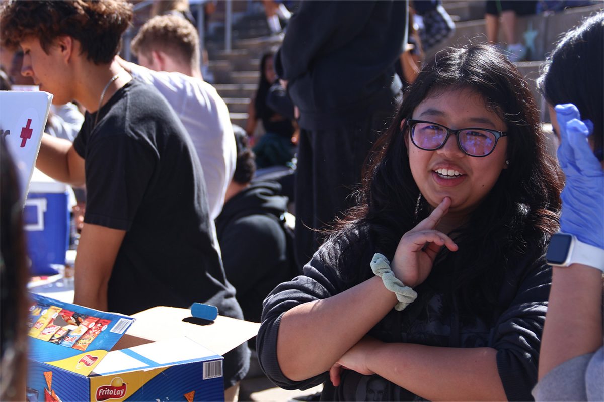 Kellie Lam thinks about a question asked while selling donuts and chips for the Red Cross Club. They aim to teach people how to prepare for emergencies and support those in need. The club also raises awareness for worldwide natural disasters.