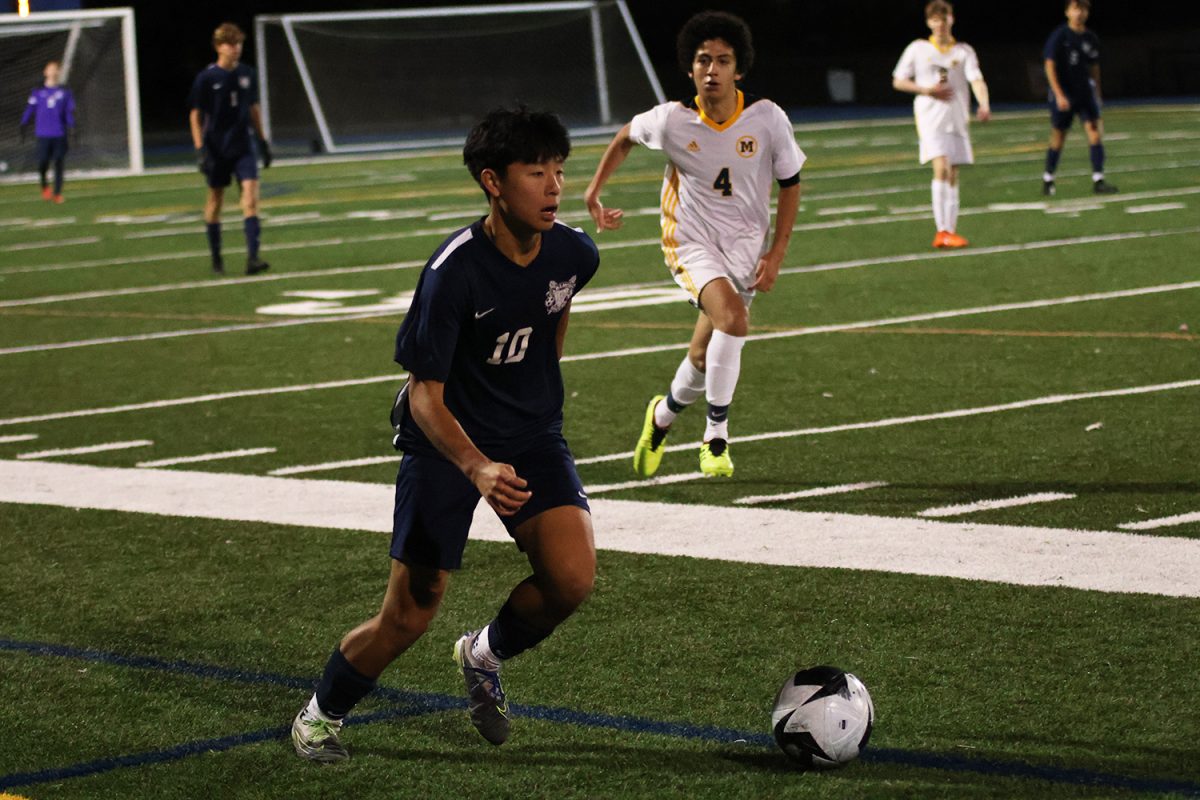 Junior Mateo Hu dribbles up the field while looking for open teammates to pass to. Carlmont did well utilizing their outside players during this game, drawing the Menlo defenders outward. This allowed them to create opportunities in the midfield, allowing them to attack with more space and time.
