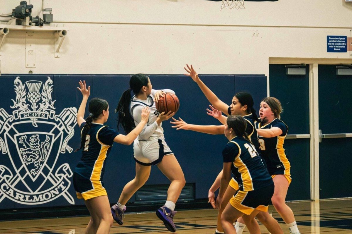 Point guard Willow Ishibashi-To jumps to shoot a layup, with many defenders blocking her. “Our plan going into the game was to out-hustle them, control the intensity, and I think we did a really good job in the first half, Ishibashi-To said.