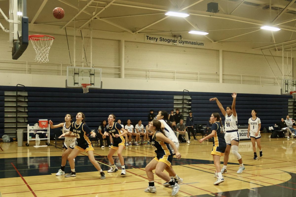 The players watch as the ball sails into the hoop in the third quarter, a score by senior Inaaya Omer. Omer is a power center, meaning that she plays near the basket while rebounding and defending taller players. The Scots were ahead 37-29 in the third quarter.