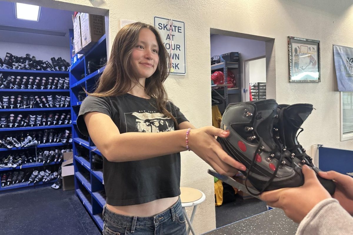 Jada Campbell hands a pair of rental skates to a customer during a public session. This is one of Campbells many responsibilities at Nazareth Ice Oasis.