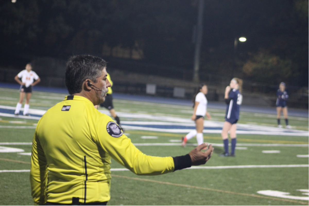 A referee in the JV girls soccer game against San Mateo makes a call on the game.