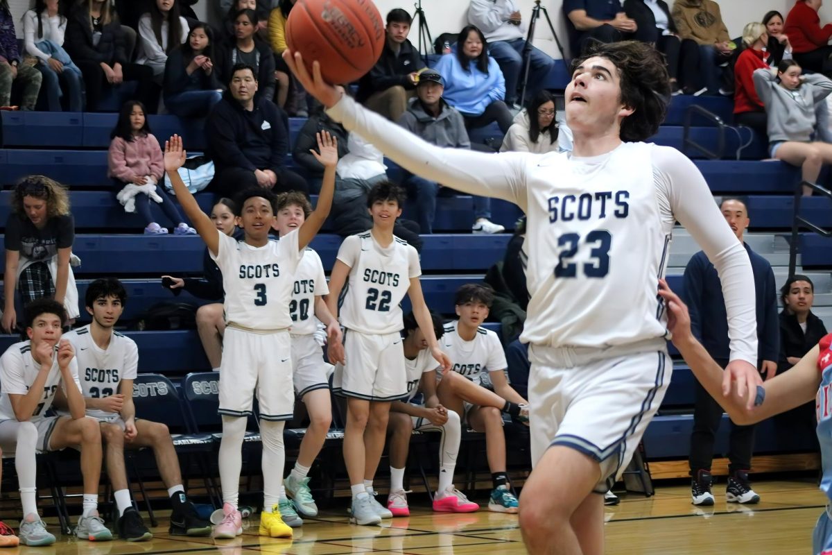 Carlmont sophomore Ryan Weiss goes in for a layup late in the fourth quarter. Weiss made the layup extending the lead for Carlmont. His teammates celebrated from behind. When we celebrate on the bench, the games are more fun, said Izzy Han, a freshman at Carlmont.