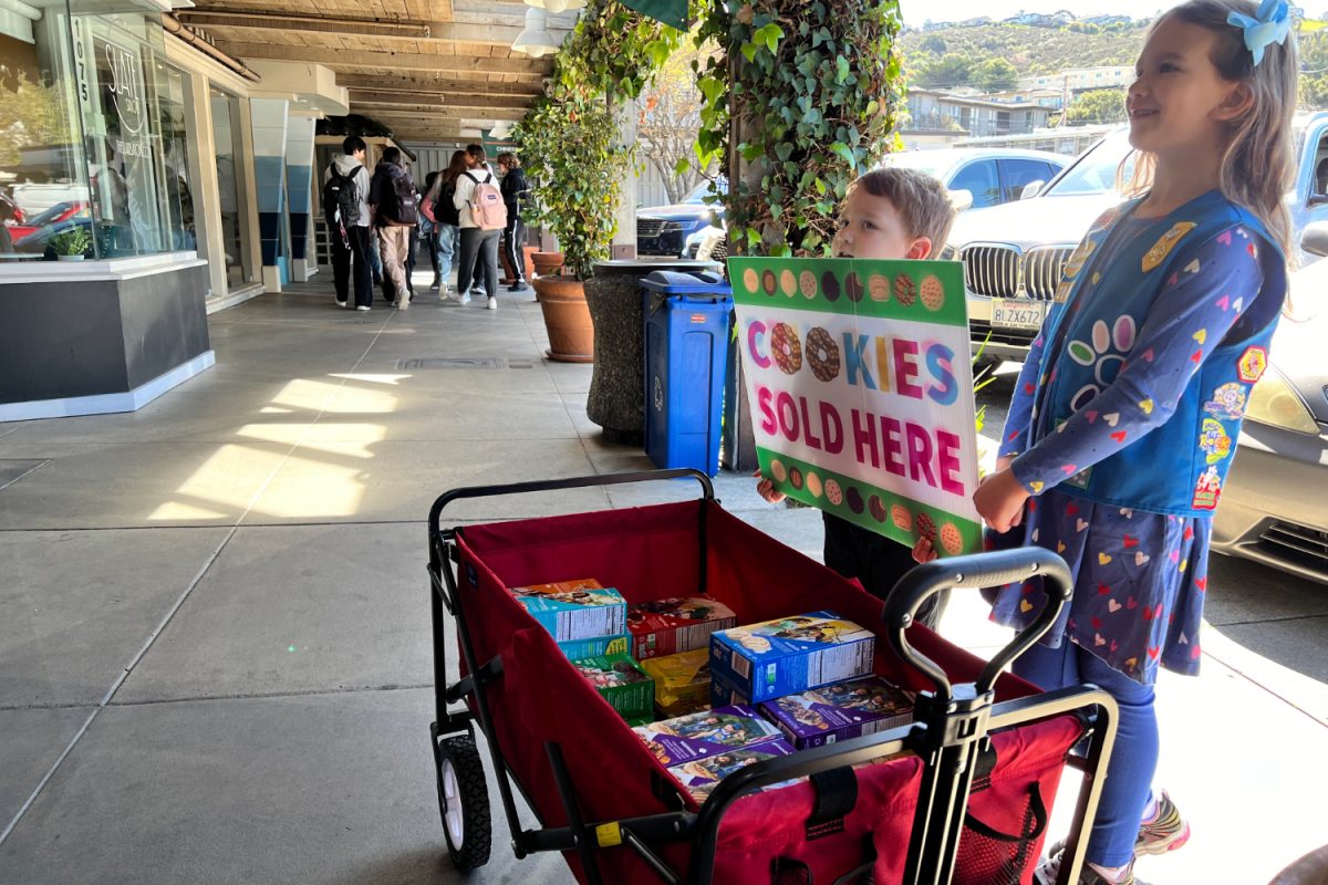 Daisy Girl Scout Evie Kaufman sells cookies in the Carlmont Shopping Center with her little brother. My goal is to sell 265 boxes this year, Kaufman said.