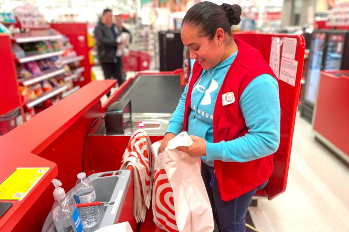 Yajaira Tapia, a Target employee, puts snacks in a thick-film plastic bag. Target is a store that provides thicker, reusable plastic shopping bags but also encourages customers to bring their own bags. We give a 5 cent discount for every bag you bring, Tapia said.