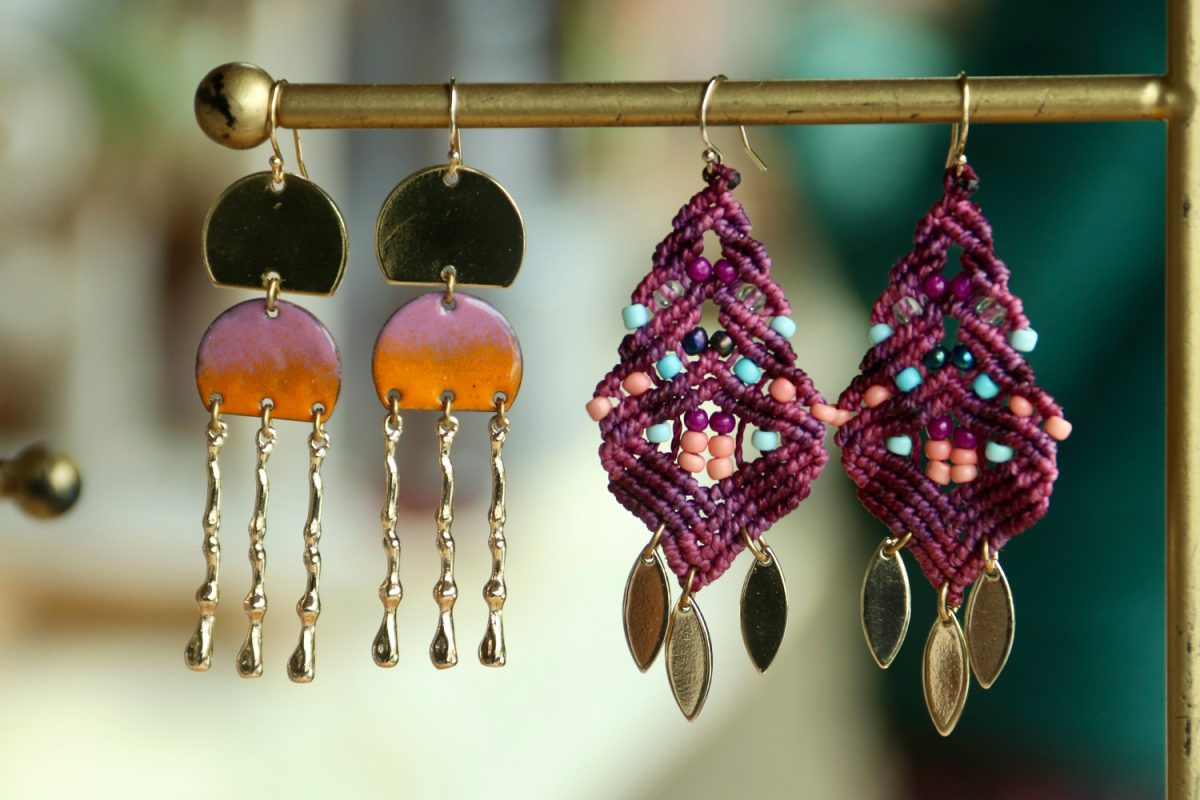 Two of Greenes earrings, the Oasis Earring and the Samara Earring are on display at her stand. The Samara Earrings hang on the right, and it is Greenes favorite type of earring to make because she uses a micro-macramé technique. This technique involves creating tiny knots on a cord to craft the desired pattern. 