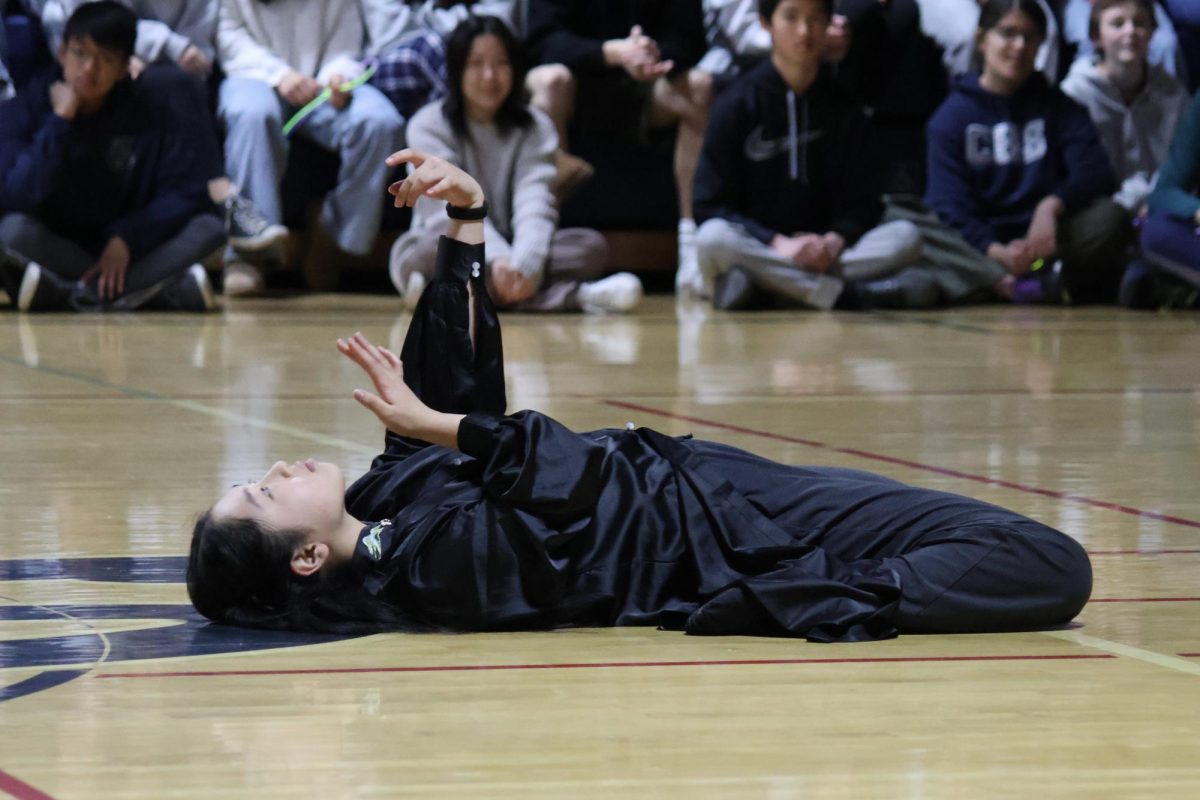 A member of the Chinese Culture Club performs a solo dance. The student began her dance lying on the ground with her hands making slow movements in the air. After rising from the ground, the dancer showcased various jumps and leaps in graceful motions. 
