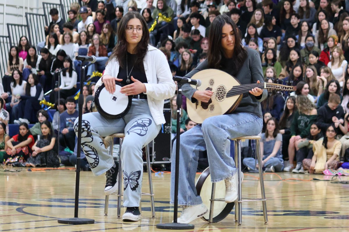 Two Turkish students perform a duet using traditional instruments. Senior Rabia Baloglu (left) plays a drum called a darbuka, while Ikbal Surucu (right) plays the oud. Together, the two create lively music that fills the room. 