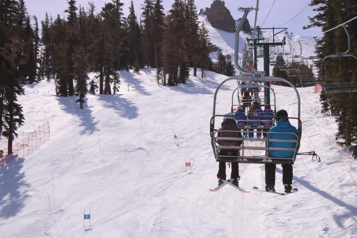 Skiers on chairlift adhere to safety protocols while going up the mountain.