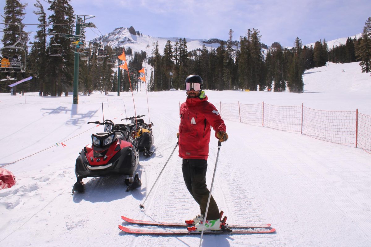 Kirkwood ski patroller, Grey Grandy poses next to a snowmobile before resuming his shift.