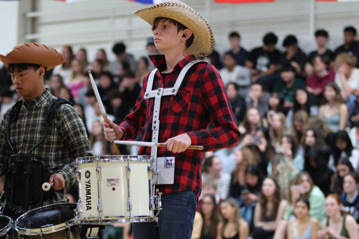 Sophomore Isaac Grinker plays the drums with other drumline members as they put on a show for the audience. Some drummers wore flannels and a cowboy hat, while others wore masks representing bulls. During their performance, a matador ran around attracting the bulls with his red flag, and by the end of the performance, the four bulls fell to the ground.
