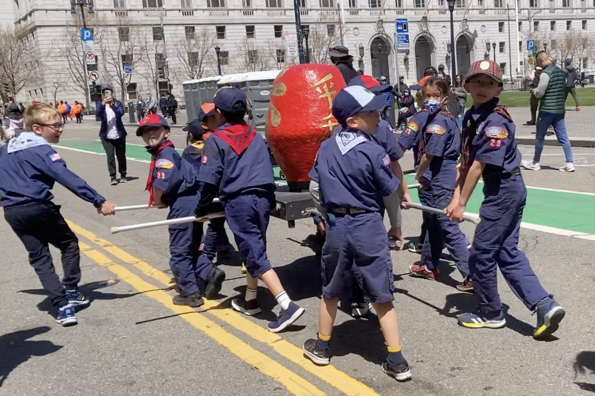 Cub Scouts, the younger age group within the troop, carry a miniature daruma in front of the BCSF troop.