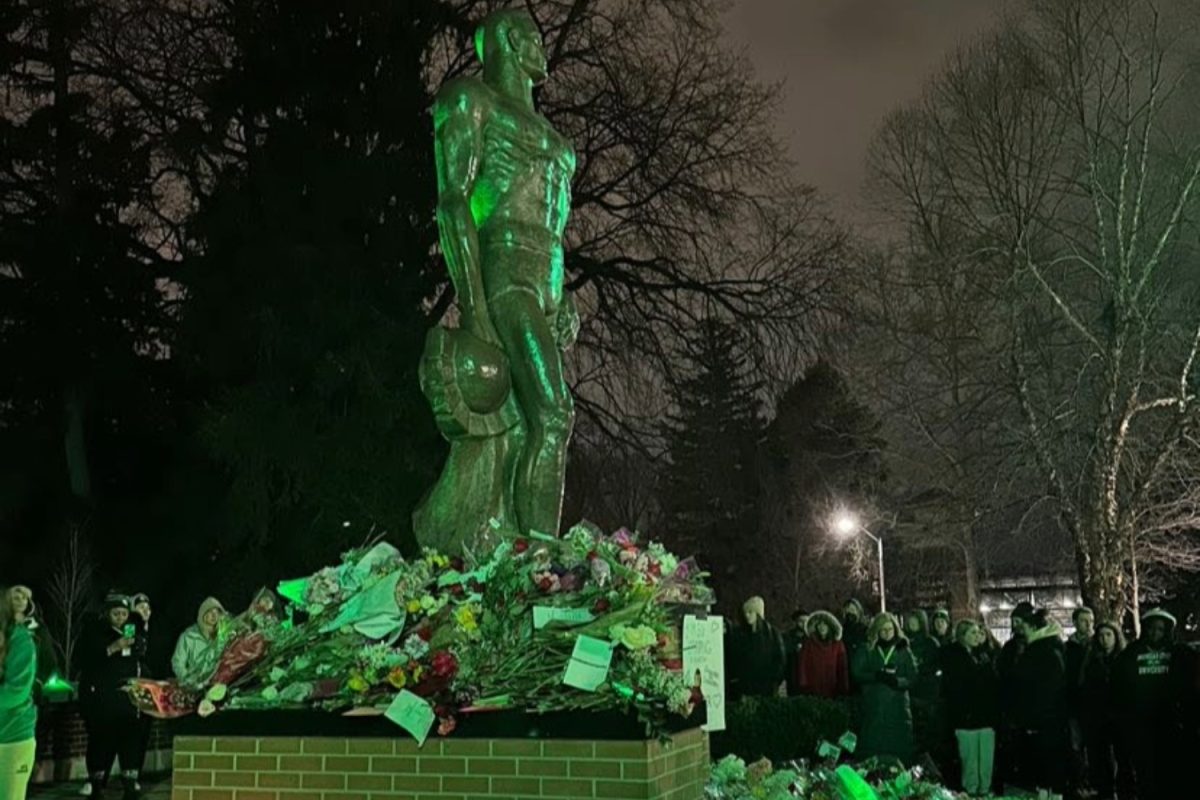 Michigan State University (MSU) students gather at a memorial to honor the four students killed in a shooting there last year on Feb. 13, 2023. Tragic events like this will continue to happen until gun control legislation is enacted to prevent them.