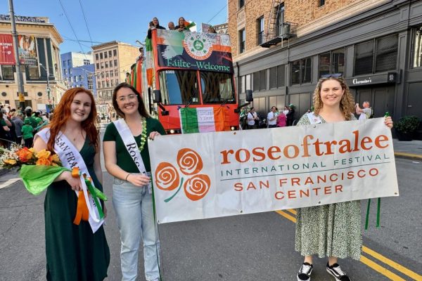 San Francisco Rose Maggie Baglin, Alana Wilson, and Erinn Sheedy hold a banner for the Rose of Tralee Festival in front of the United Irish Culture Center parade contingent. 
