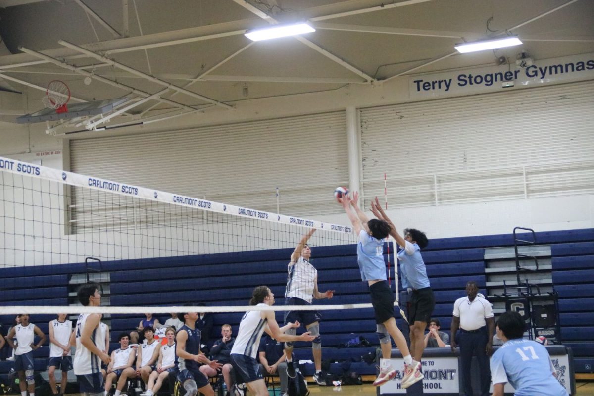 Senior+Sean+Murphy+jumps+up+to+spike+the+ball+over+two+knights+attempting+to+block+his+hit.+Murphy+was+successful%2C+earning+Carlmont+the+point.+