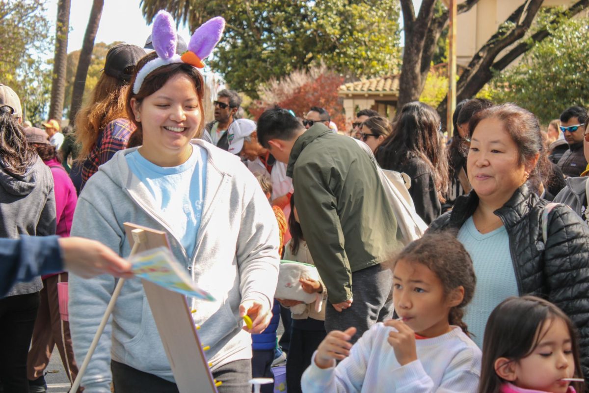 A child receives a pamphlet after spinning a prize wheel. Outside the main egg hunt areas, businesses and organizations set up booths to advertise their services.