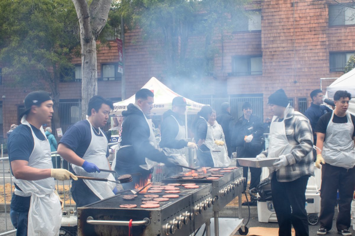 Volunteers grill patties for Teri Burgers, a festival food favorite. Senior service agency Kimochi, Inc., sold these delicacies at the festival as one of the many food booths.