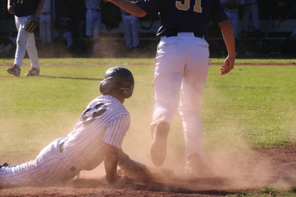 Sophomore Mitchell Giacomini dives into third in an attempt to advance on a passed ball.