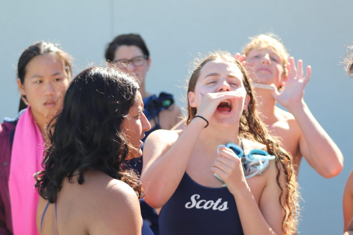 Lauren Elliott leads a cheer to keep team spirits high at a meet against Mills High School.