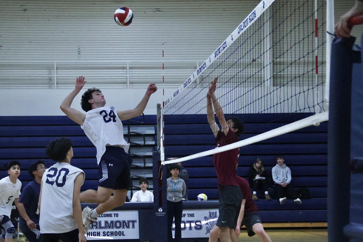 Freshman Eli Block winds up as he prepares to spike the ball over the net. A player on the opposing team attempts to block the hit but is unsuccessful as he cannot get enough height. With good timing and strong power, Block scored a point, increasing the Scots lead. 