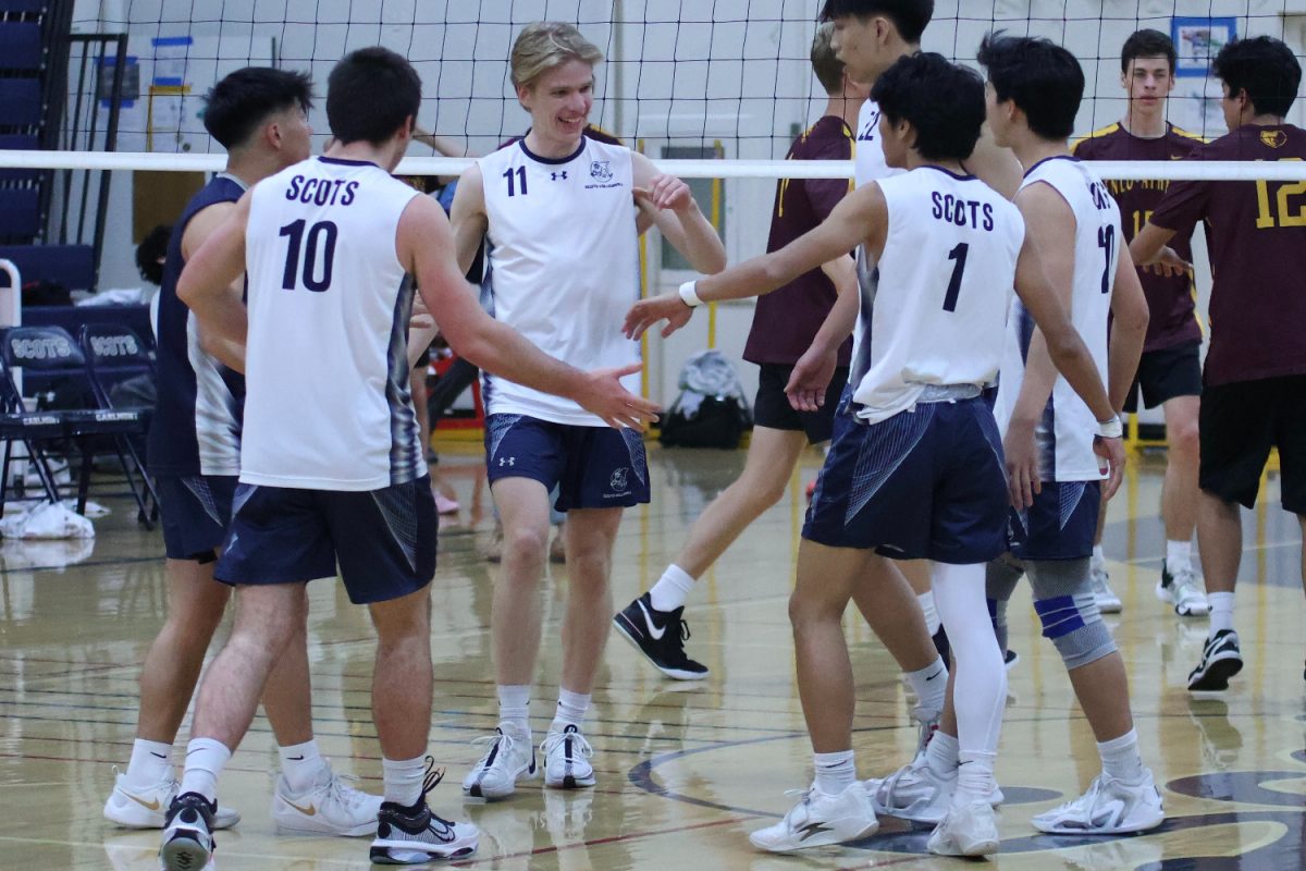 Carlmont varsity boys players high-five and congratulate senior Eric Fadeyev for scoring a point. Fadeyev was able to spike the ball over the net successfully. During the game, he scored multiple points for the Scots through various offensive plays. 