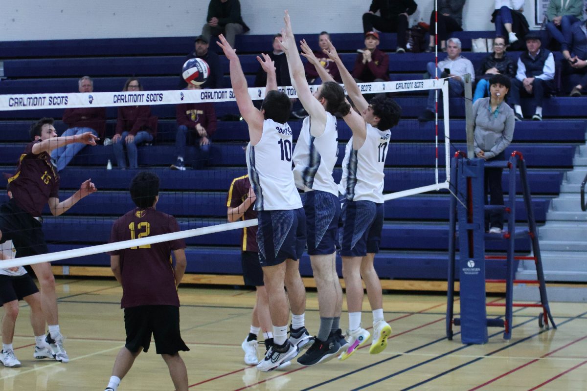 Three Carlmont players jump up in an attempt to block a spike. The Scots played a solid defensive game, often blocking hits from the Bears. This helped prevent the Bears from scoring points, as reflected by the game scores. 