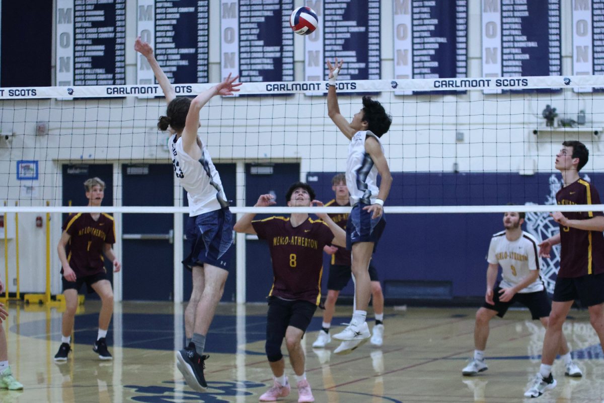 Senior Devin Engberg prepares to spike the ball after a set from senior Simon Hua. As a middle hitter, Engberg could utilize his height to score points for the Scots. He successfully made many defensive blocks and offensive spikes.