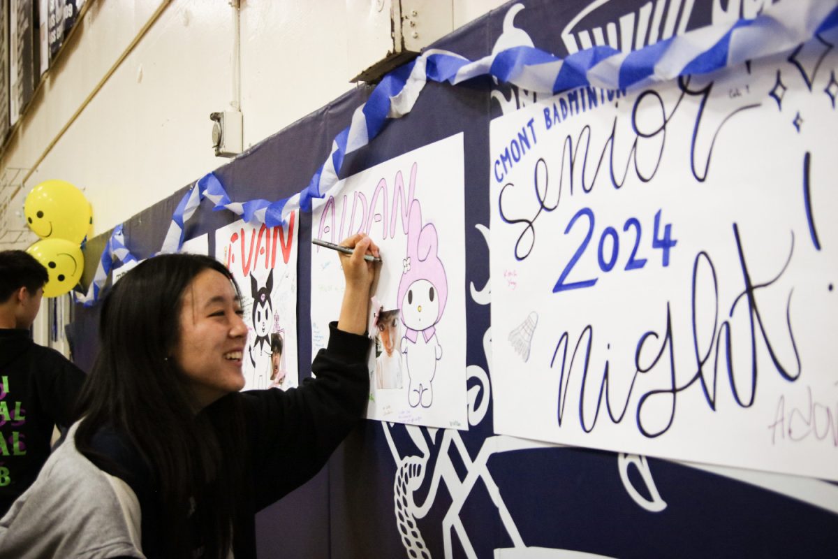 Senior Micah Cheng signs another seniors poster. On senior night, it is custom to make posters and sign them so that the seniors can take them home and remember the team.